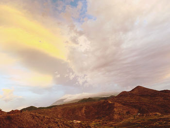 Scenic view of rainbow over landscape against sky