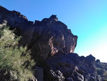 Low angle view of rock formation against clear blue sky