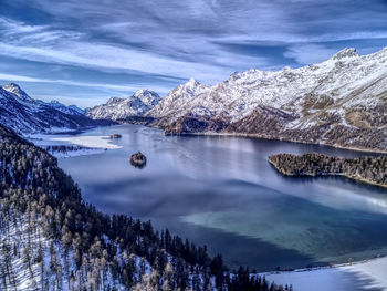 Scenic view of snowcapped mountains against cloudy sky