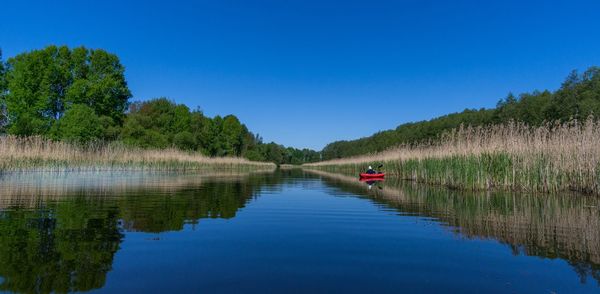 Scenic view of lake against clear blue sky