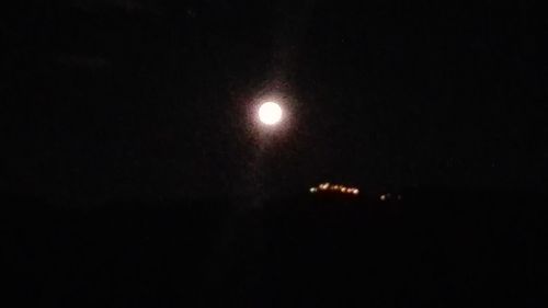 Low angle view of illuminated moon against sky at night