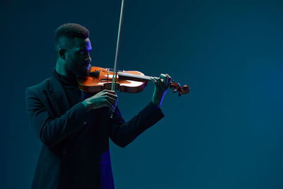 Midsection of man playing violin