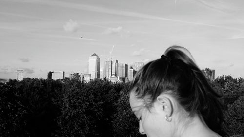 Mid adult woman against sky in city