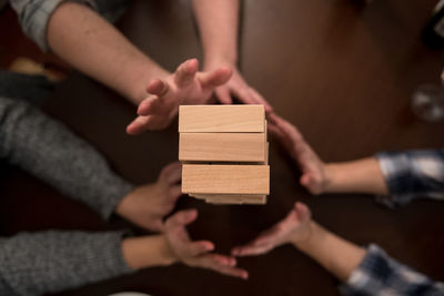 Directly above view of people playing jenga on table