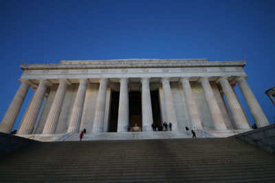 Low angle view of statues on steps against clear sky