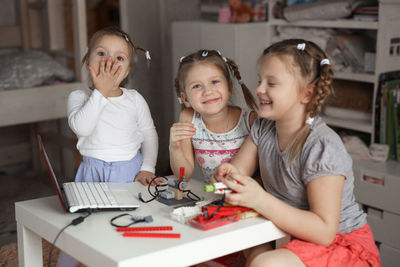 Portrait of siblings sitting at home