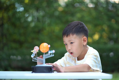 Portrait of boy sitting on table