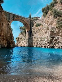 Arch bridge over river against sky