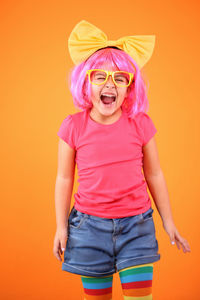 Full length of a girl standing against yellow background