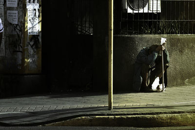 Man sitting on footpath