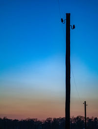Low angle view of silhouette pole against clear sky during sunset