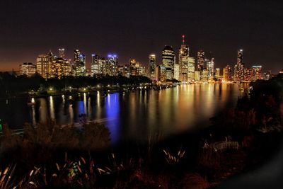 Brisbane river in front of illuminated buildings at night