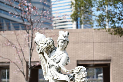 Statue against building and trees