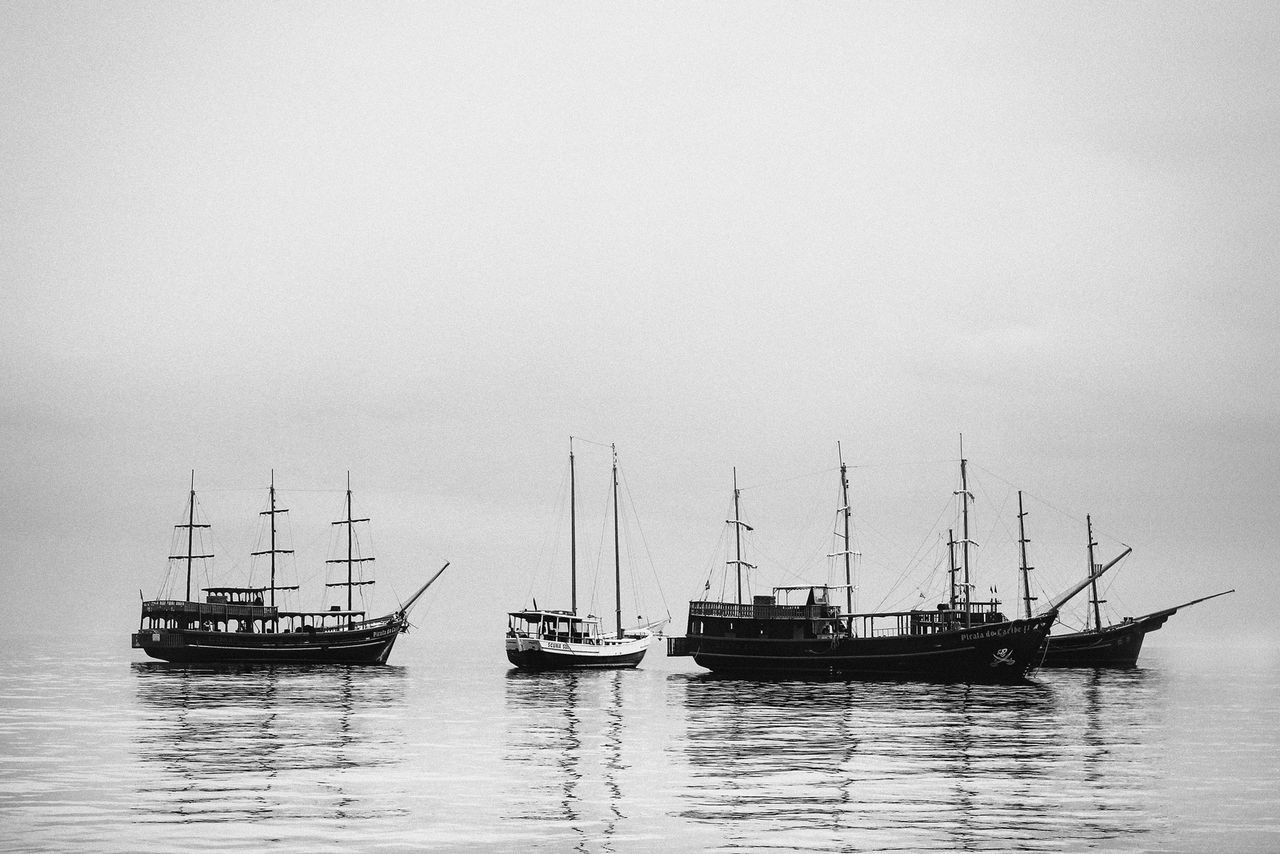 BOATS SAILING ON SEA AGAINST SKY