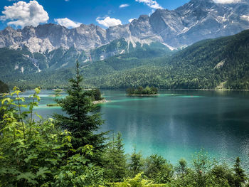 Scenic view of lake by mountains against sky