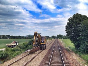 Railroad track against cloudy sky