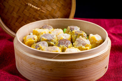 Close-up of dim sums in bamboo steamer on table