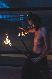 Male fire performer juggling on footpath