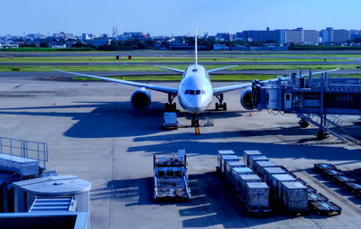 High angle view of airplane on airport runway against sky