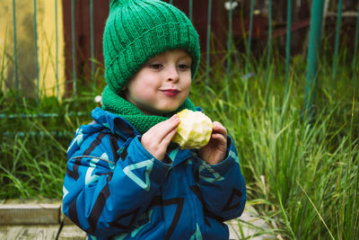 Child eating delicious apple outdoors, fruit snack. healthy food concept