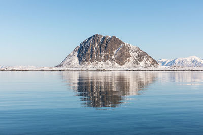 Scenic view of lake and mountains against clear blue sky