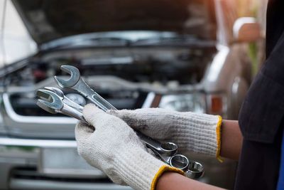 Cropped hand of mechanic holding equipment