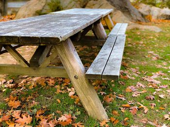 Empty bench and table on field during autumn