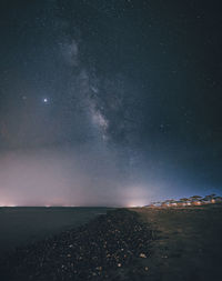 Scenic view of sea against star field at night