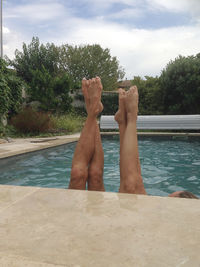 Low section of man relaxing in swimming pool