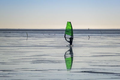 An alone surfer ice boarding on the frozen sea.