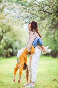 Full length of mother with daughter standing at park