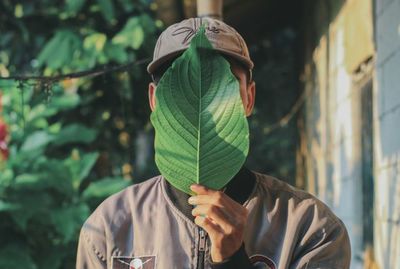 Portrait of person holding leaf outdoors