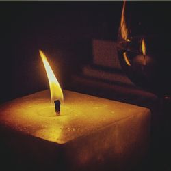 Lit candle in dark room