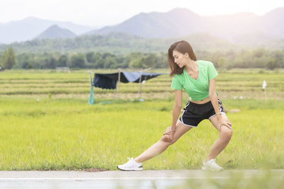 Full length of young woman lying on field