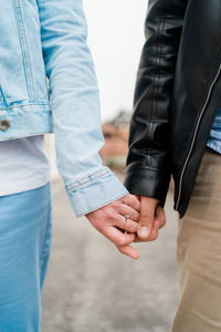 Midsection of couple holding hands