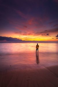 Full length of man standing on beach during sunset