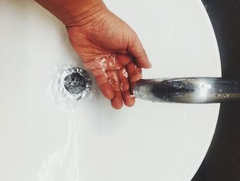 Close-up of person washing hand in sink