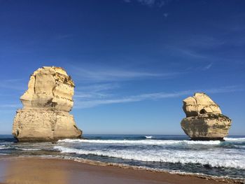 Rock formation on beach against sky