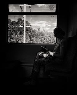 Side view of young woman reading book