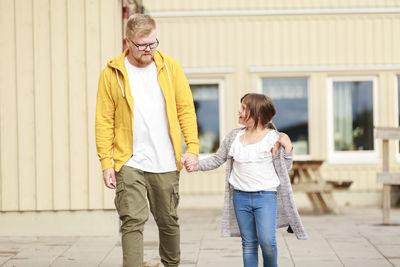 Full length of a smiling young woman standing outdoors