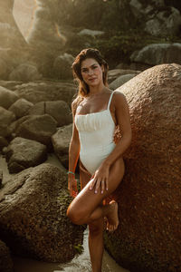 Portrait of young woman sitting on rock