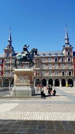 Statue in city against clear sky