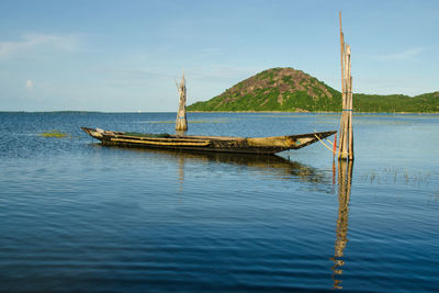 Boat moored on sea against sky