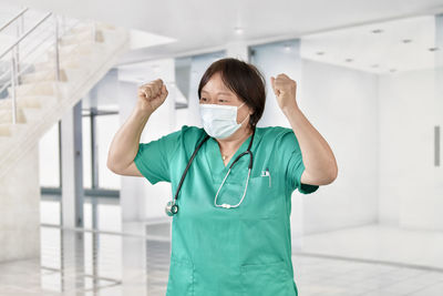 Portrait of young woman with arms outstretched