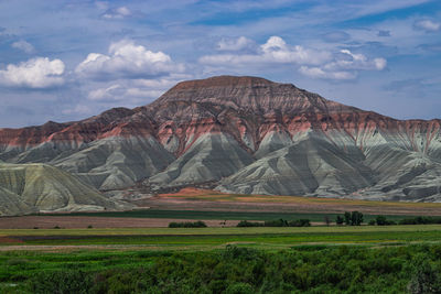 Scenic view of field and mountains against sky
