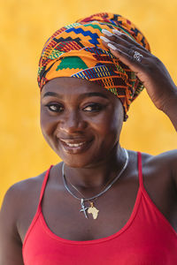 Happy african woman with a yellow wall in the background in the small village of keta ghana