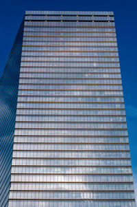 Low angle view of modern building against clear blue sky