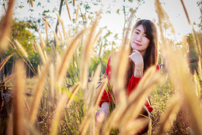 Portrait of beautiful young woman on field