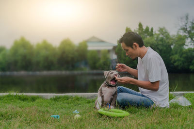 Side view of woman with dog on field