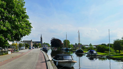 Sailboats moored on lake against sky